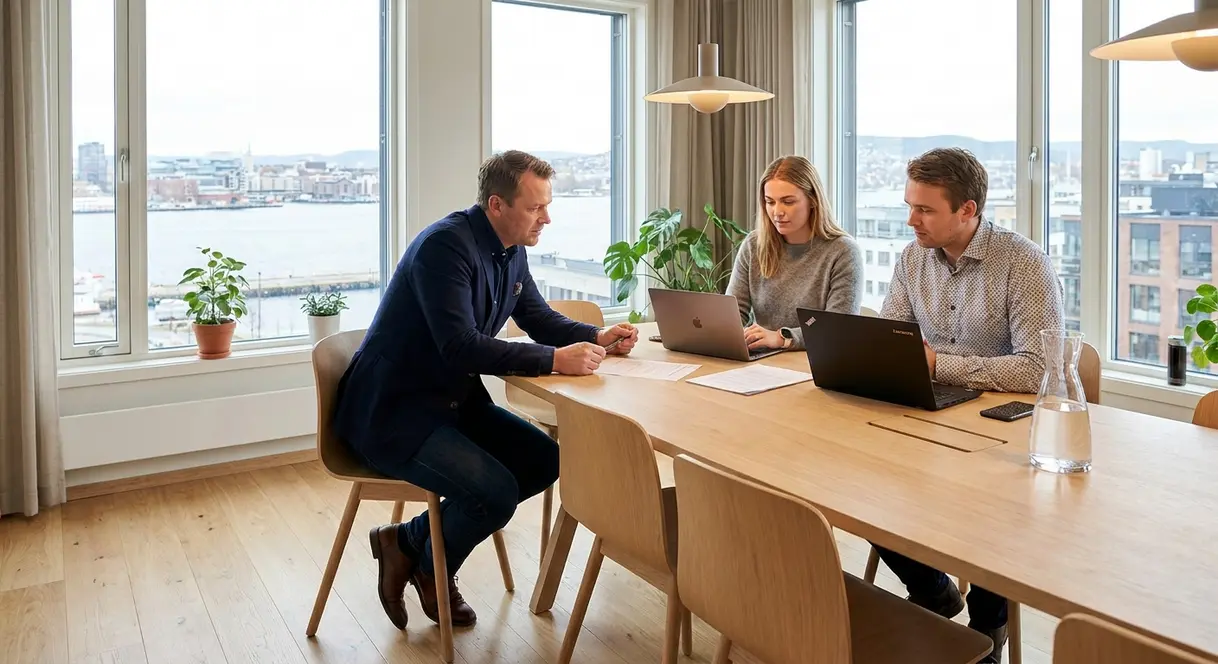 En leder i samtale med verneombud og tillitsvalgt rundt et møtebord på en norsk arbeidsplass